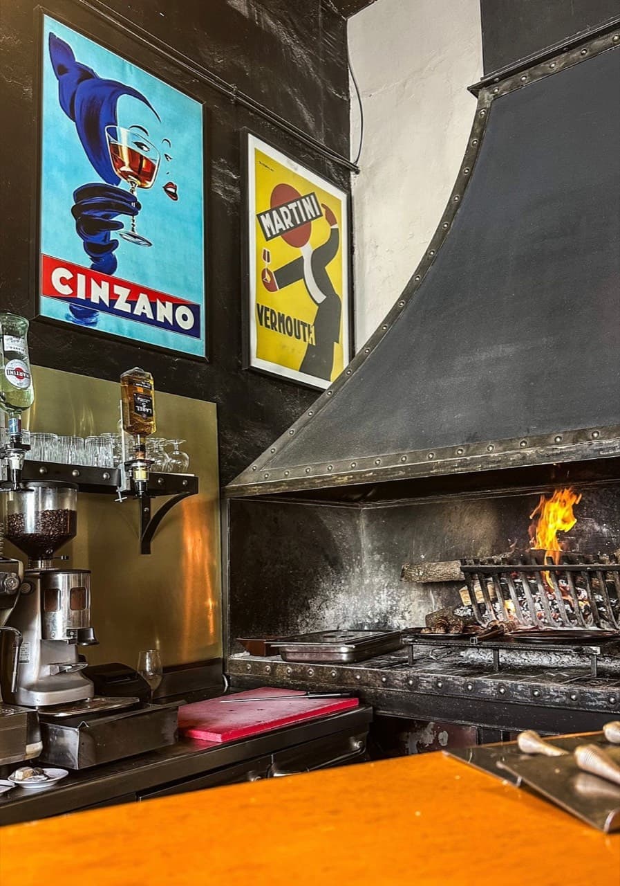 Cheminée à braise au centre de la salle du restaurant