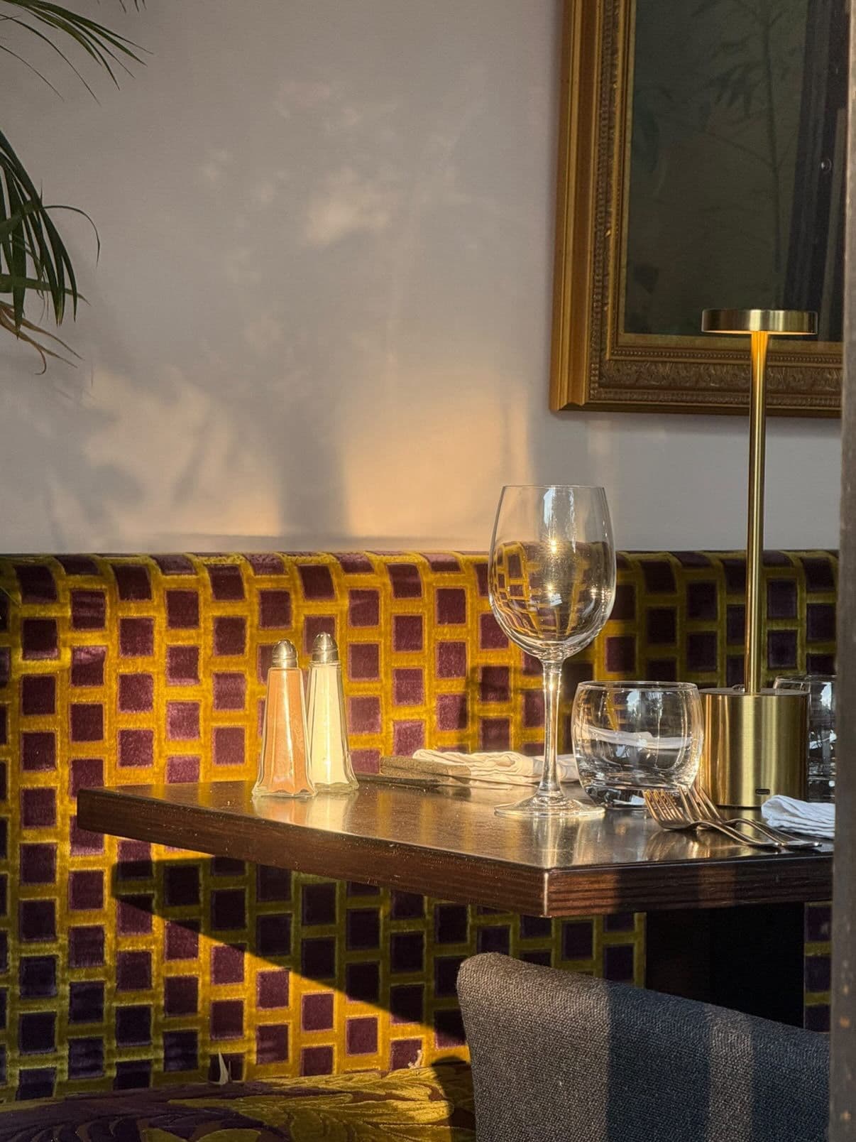 Table en bois dressée avec verres et couverts en salle
